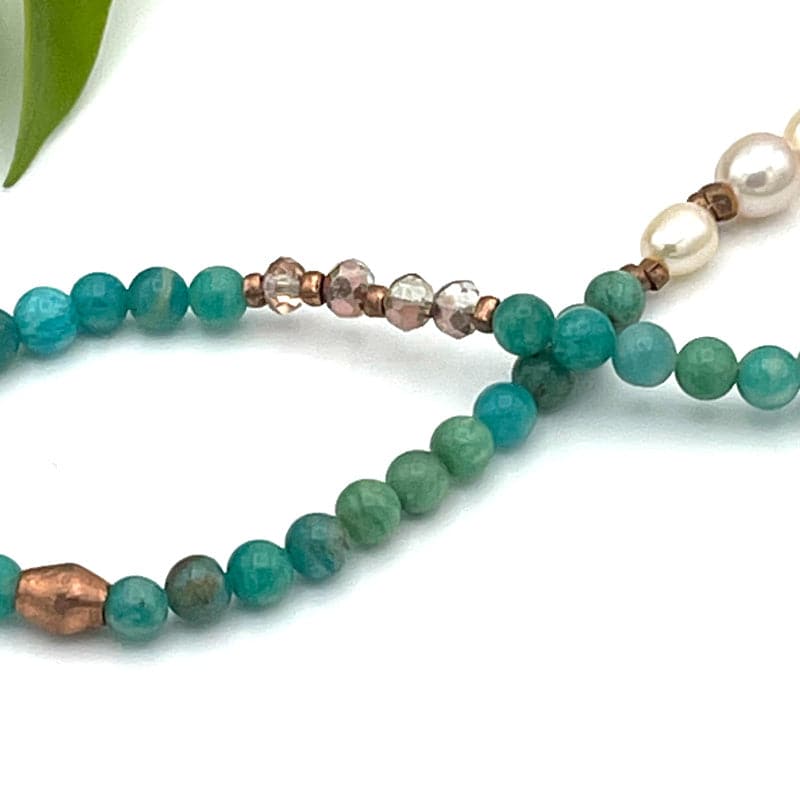 Close up of rose gold crystals beads on Amazonite and Pearl gemstone necklace.